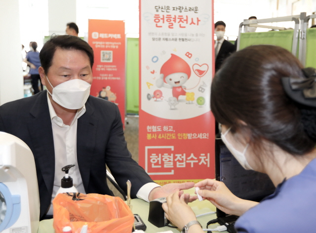 최태원 SK그룹 회장이 28일 서울 중구 SK텔레콤 T타워에서 열린 코로나19 극복 릴레이 헌혈 행사에 예고 없이 방문한 뒤 헌혈에 앞서 문진을 하고 있다. /SK그룹 제공