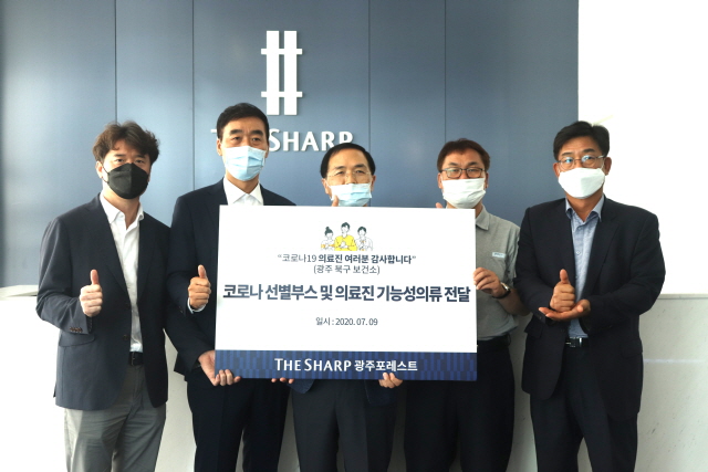 포스코건설과 근화이앤씨 관계자들이 광주 북구 보건소에 선별진료소 부스와 기능성 의류를 전달하고 기념촬영을 하고 있다./포스코건설 제공